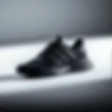 Elegant black Adidas sports shoes on a minimalist background